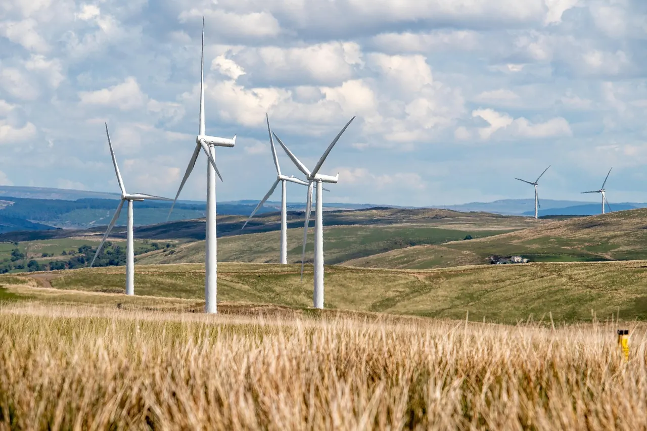 Éoliennes dans un champ sous un ciel nuageux