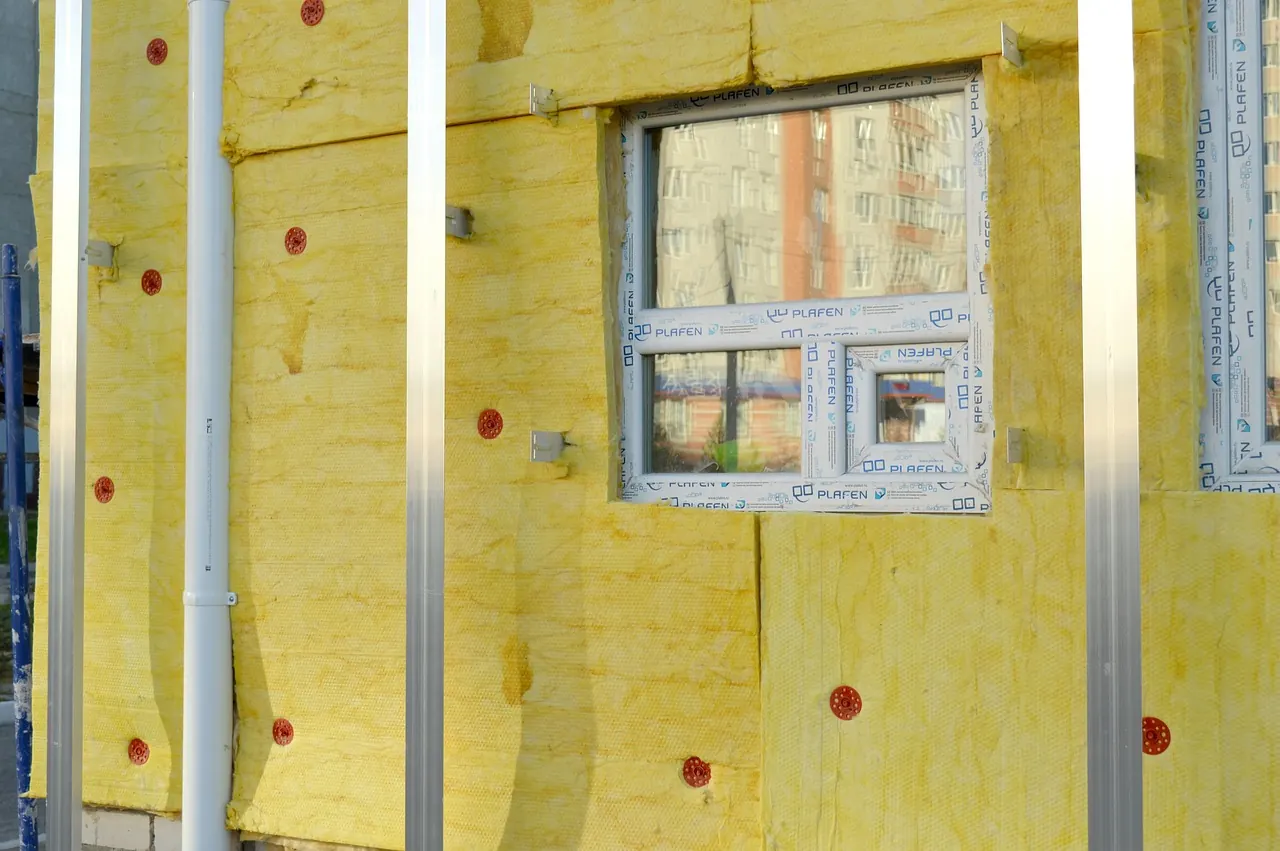 Panneaux d'isolant posés sur un mur autour d'une fenêtre pendant des travaux