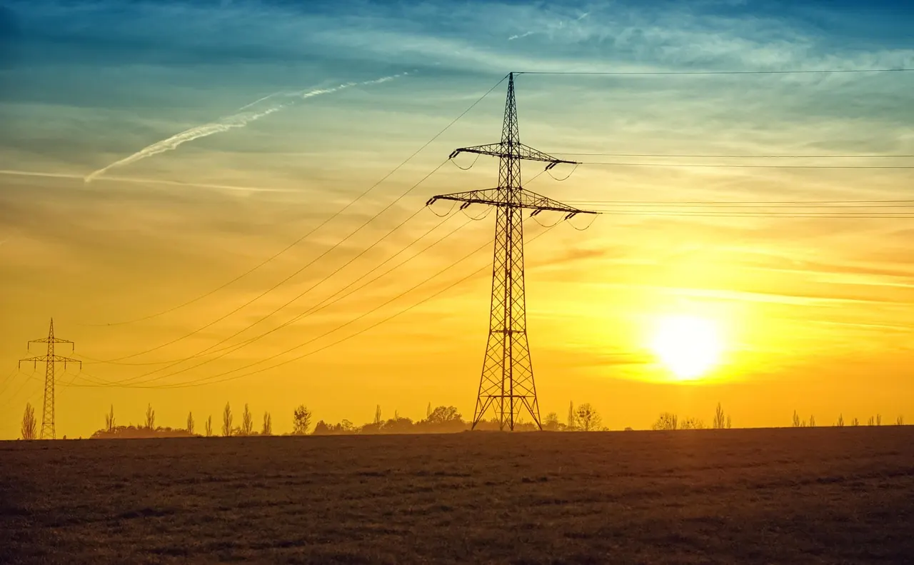 Pylône électrique et lignes à haute tension au coucher du soleil